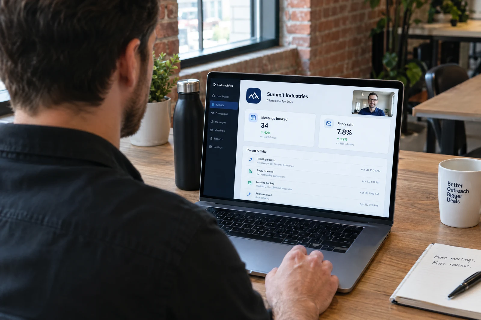 An agency founder on a client call, his laptop showing a client portal with meetings booked and reply rate